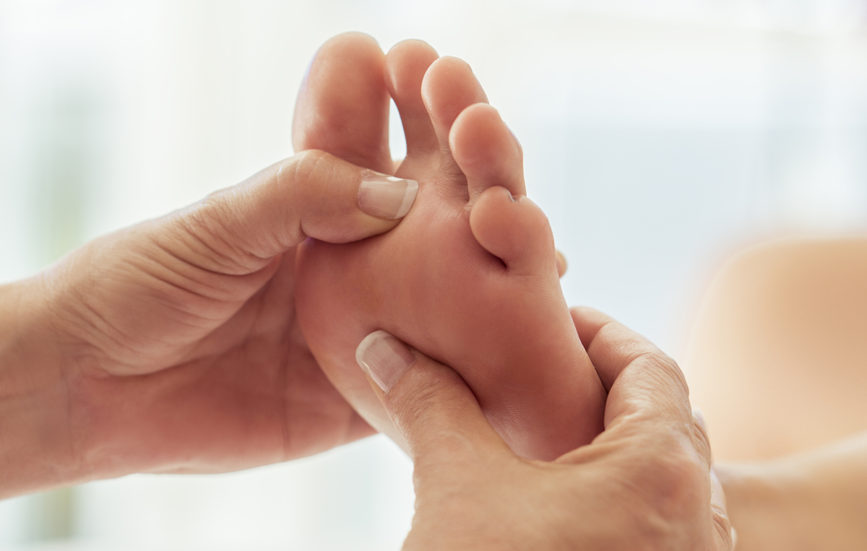 Mains effectuants des pressions sur la voute plantaire pour la réflexologie Alliance Pornic