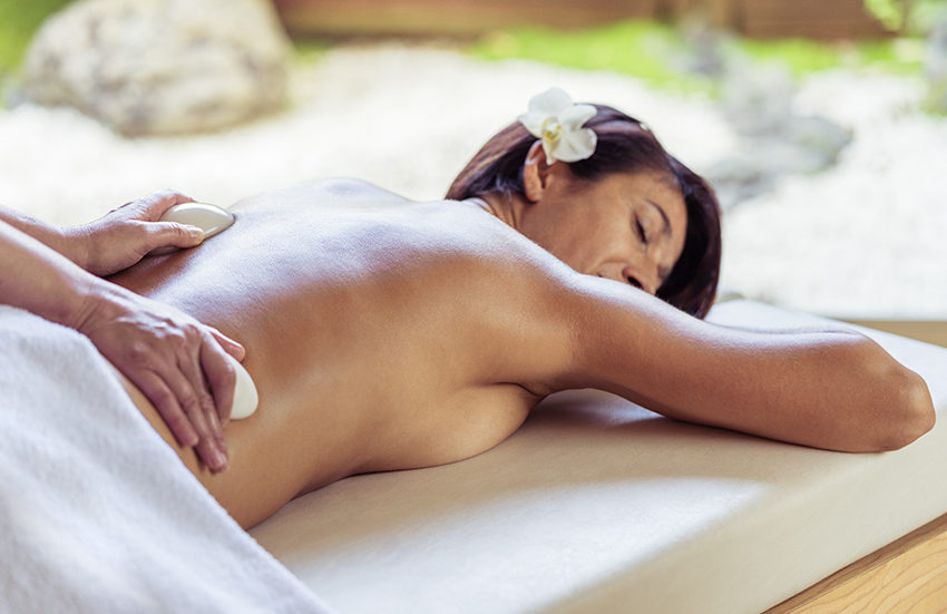 Main tenant une pierre de Jade sur le dos d'une femme pour un massage Maya Alliance Pornic