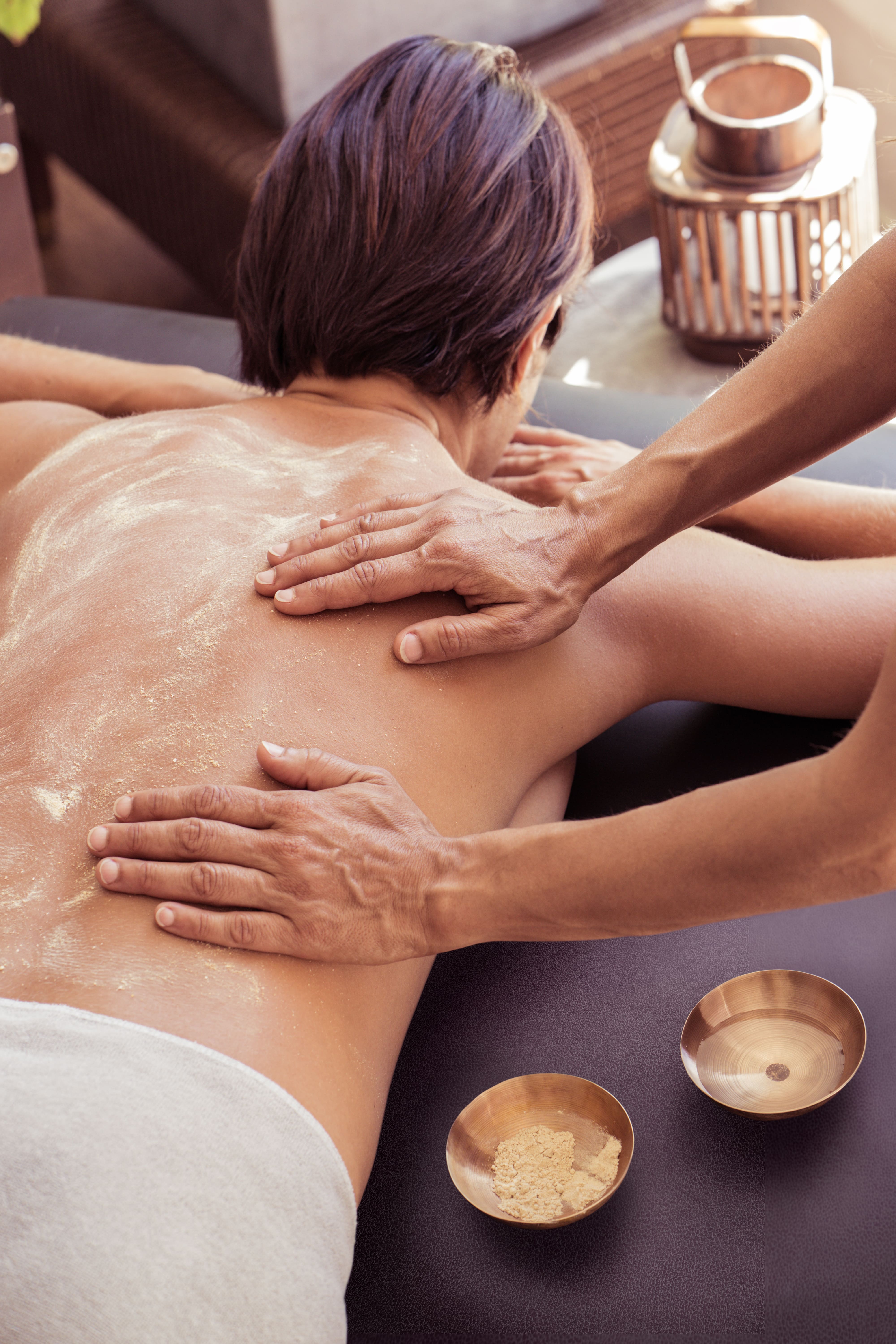 mains posées sur le dos d'une femme pour un Udvartana Alliance Pornic