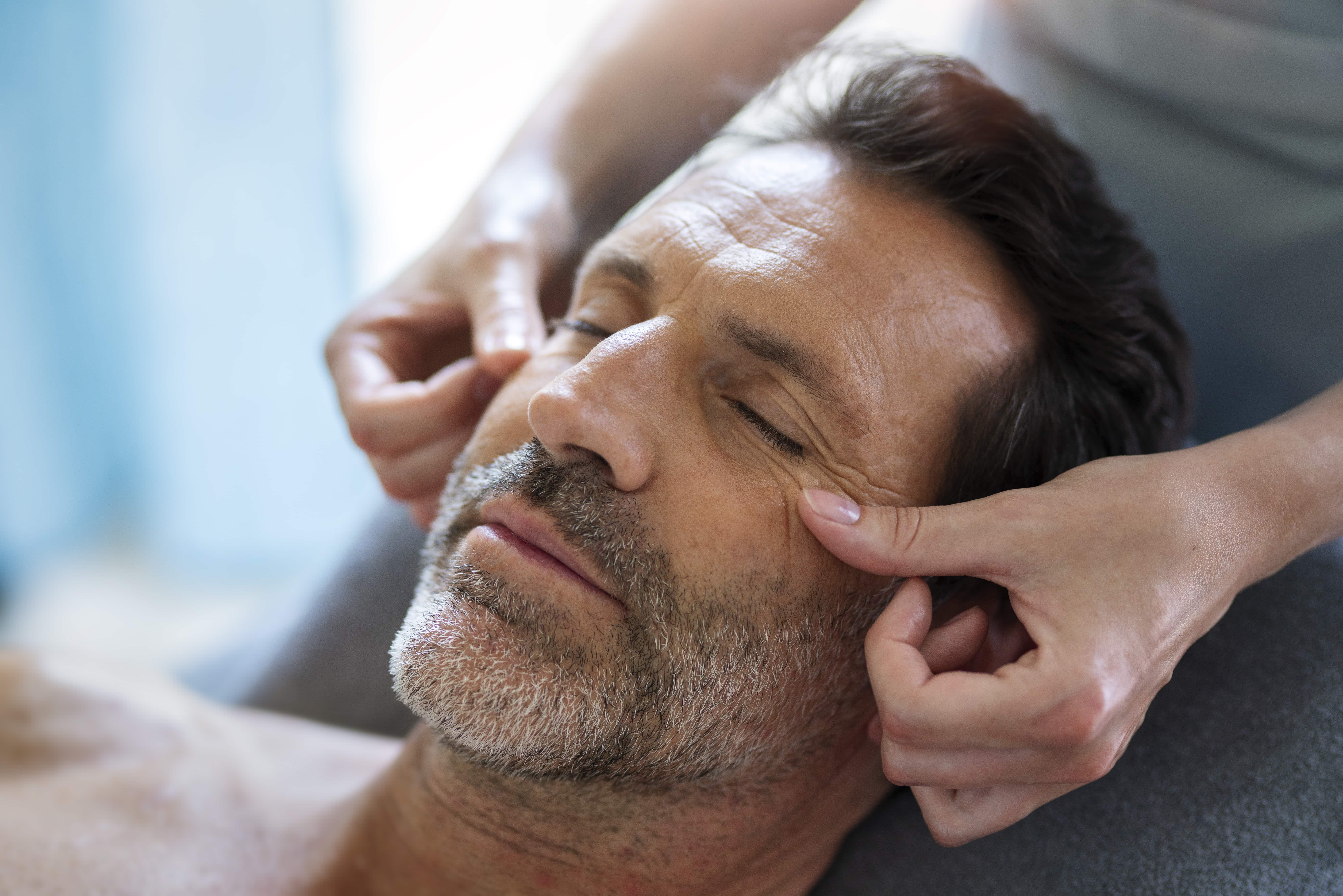 Main posée sur le crâne d'un homme pour massage visage et cuir chevelu Alliance Pornic