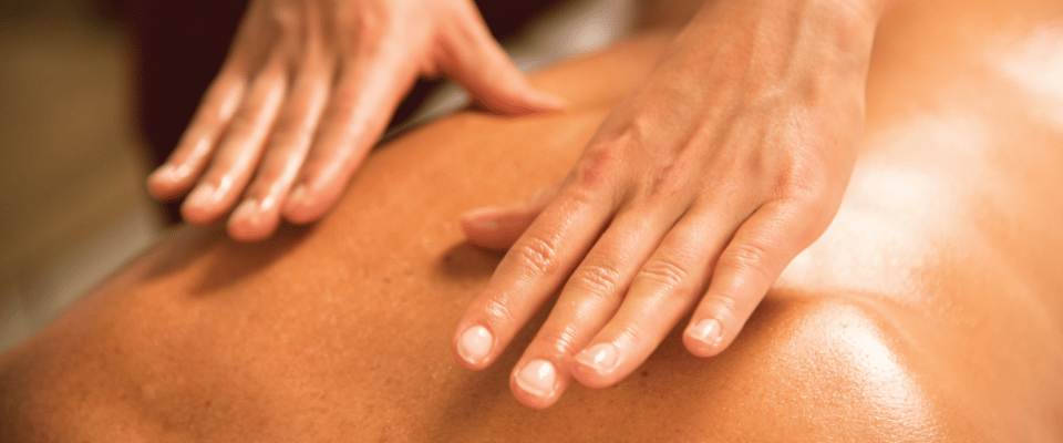 Femme allongée sur le ventre avec 2 mains posés sur son dos pour un massage
